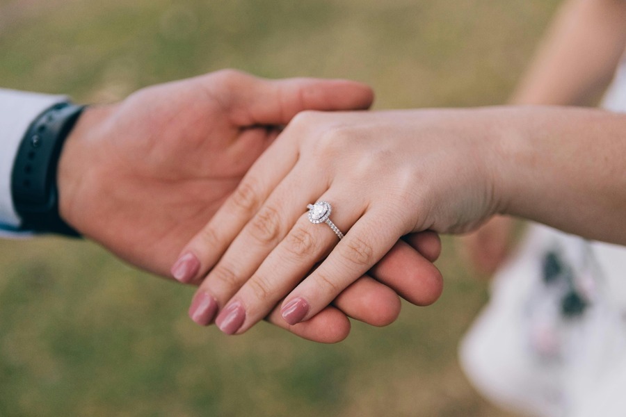 Person looking thoughtful while others celebrate engagements